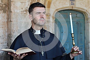 Religious man holding the Bible and a candle