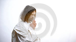 Religious man praying to God, light falling as sign of forgiveness, God mercy