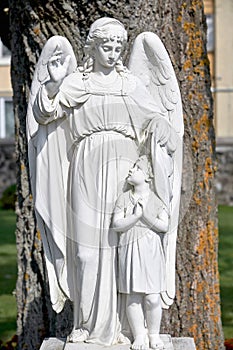 Religious monument of the guardian angel. Monument to the angel made of white stone
