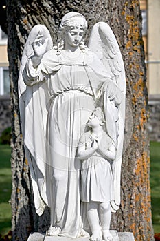 Religious monument of the guardian angel. Monument to the angel made of white stone photo