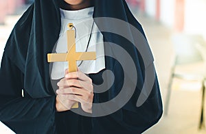 Religious nun in religion concept. Hands praying to the GOD while holding a crucifix symbol . Nun holding a cross in his hands.