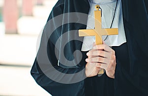 Religious nun in religion concept. Hands praying to the GOD while holding a crucifix symbol . Nun holding a cross in his hands.