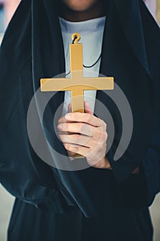Religious nun in religion concept. Hands praying to the GOD while holding a crucifix symbol . Nun holding a cross in his hands.