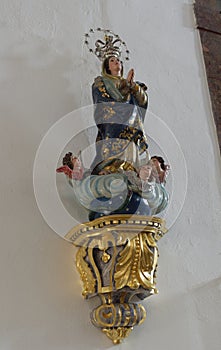 A Religious and ornately carved and painted wall Statue on the inside walls of the Paroquia de San Martinho.