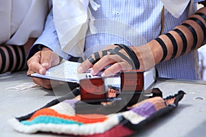 Religious orthodox with arm-tefillin on his left hand prays