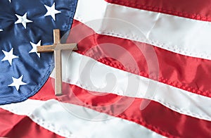 Religious right concept with Christian Wooden cross on American flag background
