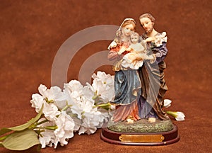 A Religious Scuplture With White Flowers
