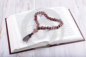 Religious theme holy book and cross on a white wooden background