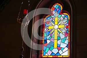 Religious theme yellow cross in leadlight window with colours blue,red and orange