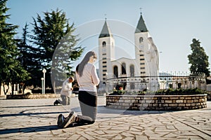 Religious woman praying to God and Virgin Mary in Medjugorje.Woman in emotional stress and pain.Christianity.Strong religion,faith