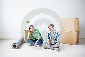 Relocation, real estate and moving concept - young couple people moved to a new apartment