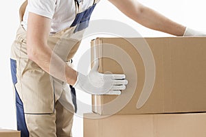 Relocation services concept. Mover in uniform with cardboardboxes isolated on white background photo