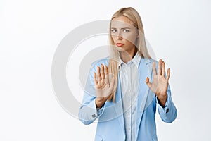 Reluctant corporate woman in blue suit making cross taboo gesture, refusing something, decline bad offer, standing over