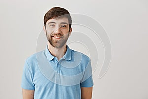 Rely only on true friends. Indoor shot of positive good-looking man with beard smiling friendly and happily while