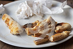 Remainders of pizza and used napkins on a white plate. photo