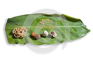 The remaining torque and dessert on a plain banana leaf after eating on festival meal