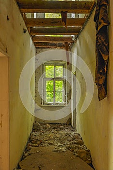 Remains of abandoned damaged and destroyed house interior with collapsed roof and wal.