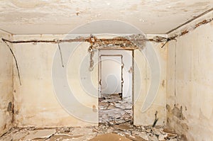 Remains of abandoned damaged and destroyed house interior by grenade shelling with collapsed roof and wall in the war zone selecti