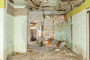 Remains of abandoned damaged and destroyed house interior by grenade shelling with collapsed roof and wall in the war zone selecti