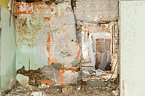 Remains of abandoned damaged and destroyed house interior by grenade shelling with collapsed roof and wall in the war zone selecti