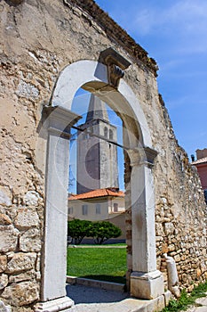 Remains of an arched Roman Gate in a park in the old town of Porec also called Parenzo, in Croatia, with the Euphrasian Basilica