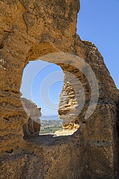 The remains of the city walls of the ancient Greek Akragas as a window on the panorama. The sea as background. Agrigento, Sicily, photo