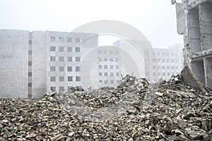 The remains of concrete fragments of gray stones on the background of the destroyed building in a foggy haze