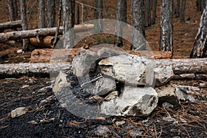 The remains of a fire in the forest. A pile of rocks and ashes from burning trees