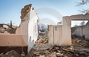 Remains of hurricane or earthquake aftermath disaster damage on ruined old houses with collapsed roof and wall