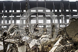 The remains of a large concrete building in the form of fragments of piles and piles of stones