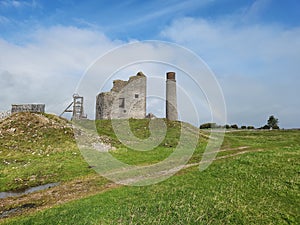 the remains of an old abandoned castle standing on a grassy hill with a rainbow