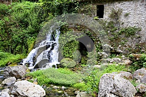 Remains of an old abandoned mill and water cascade with lush vegetation, Morigerati, Cilento, Campania, Italy