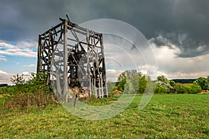 Remains of old burnt windmill in the field before the rain