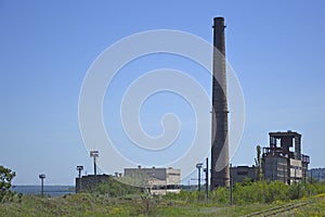 Remains of an old industrial plant or factory and a lone chimney