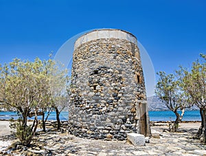 Remains of an old, stone windmill on the Kolokitha peninsula near the town of Elounda, Crete