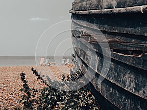 Remains old wooden boat rotting away in foreground on Brighton Beach