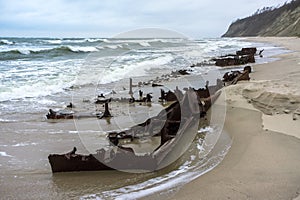 The remains of a seagoing vessel on the shore. Old Rusty Ship. The rusted wreckage of an old ship