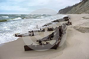 The remains of a seagoing vessel on the shore. Old Rusty Ship. The rusted wreckage of an old ship