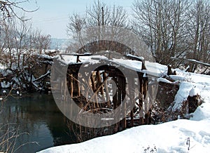 Remains of a wooden bridge on the Mlava River under the snow.