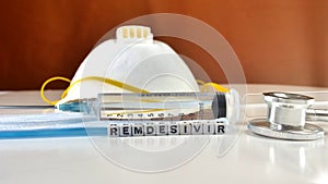 Remdesivir antiviral and mask n 95 and stethoscope on orange background photo