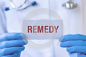 Remedy - text on card and doctor holding it.
