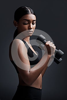 Always remember that strength is judged by perseverance not weight. Studio shot of a young sportswoman doing dumbbell