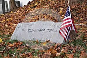 We Remember Them carved on grave marker with American Flag and medallion