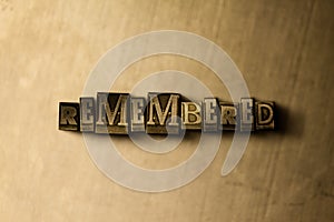 REMEMBERED - close-up of grungy vintage typeset word on metal backdrop