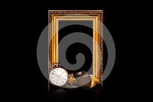 Remembrance of loss. Personal keepsake items. Empty golden wooden frame with an old pocket watch and steel dog tag on black backgr