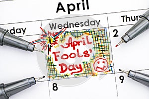 Reminder April fools day in calendar with four pens.