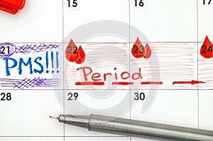 Reminder PMS and Period in calendar with pen. Closeup.