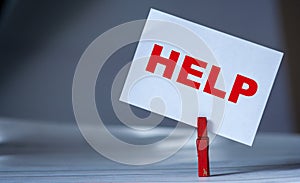 Reminder sticky note with clothes pin on table. Sticky note with word HELP. Support and assistance concept. Solve problem