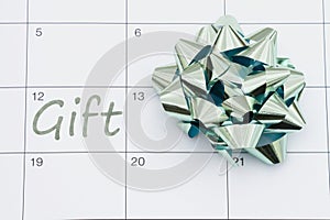 Reminder to get a gift with teal bow on a calendar