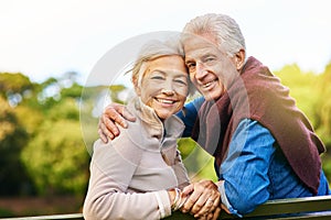 Reminding you what love is all about. Portrait of a happy senior couple sitting on a park bench.